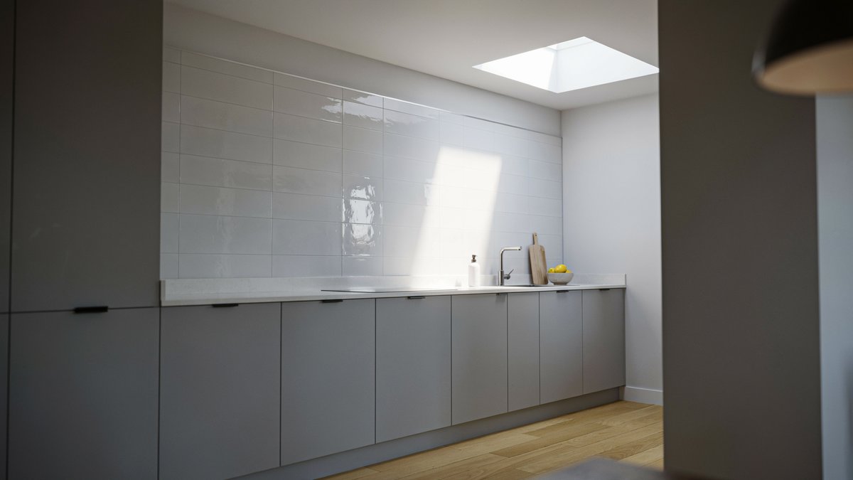 Glossy white tile walls and gray base cabinets lit by a skylight