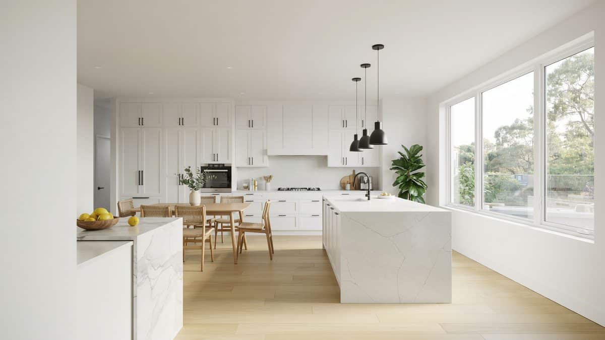 Flat panel cabinets and a quartz waterfall island open to a sunlit dining area