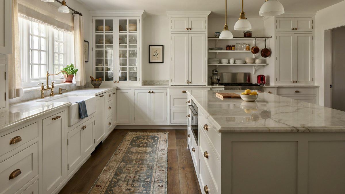 Glass pane cabinets and a marble island above a patterned runner rug