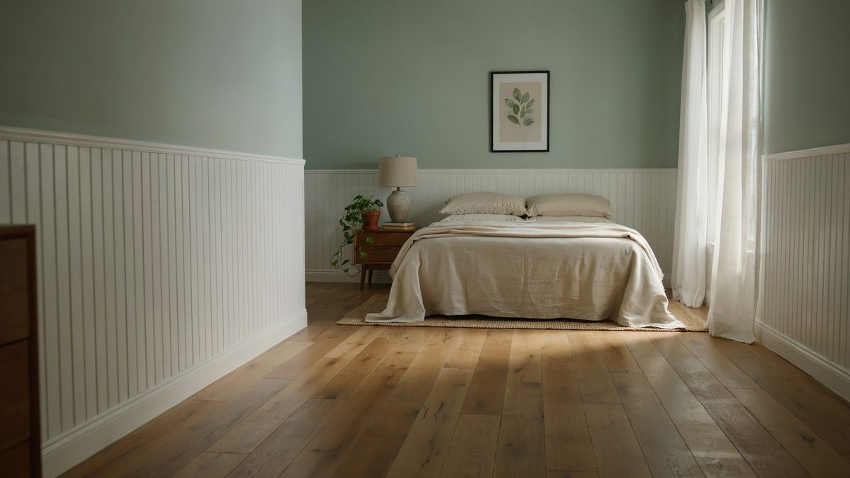 Sage green walls above white beadboard wainscoting with honey oak plank floors