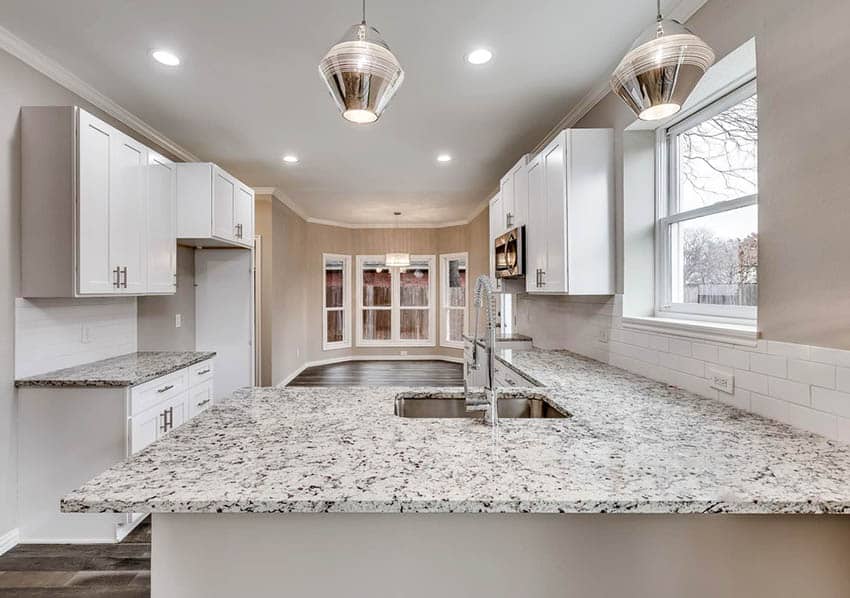 Contemporary kitchen with dallas white granite countertops and white shaker cabinets