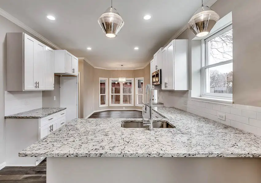 Kitchen with granite countertops and white shaker cabinets