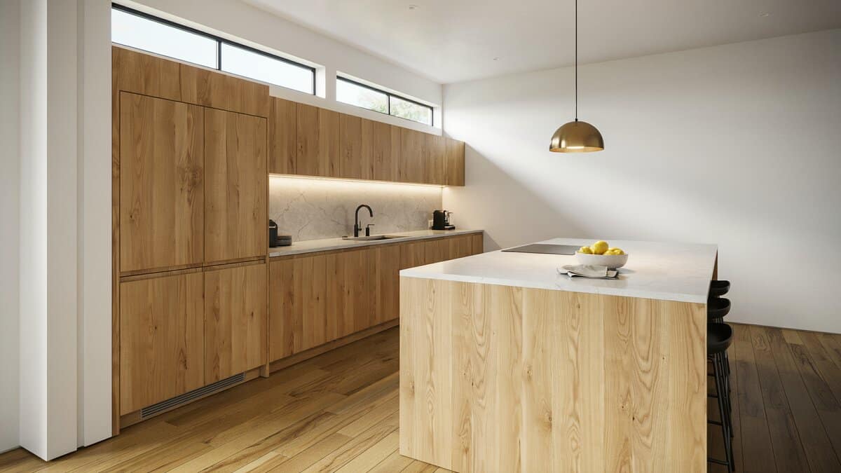Clerestory windows above pale gray walls, wood cabinets and a square center island