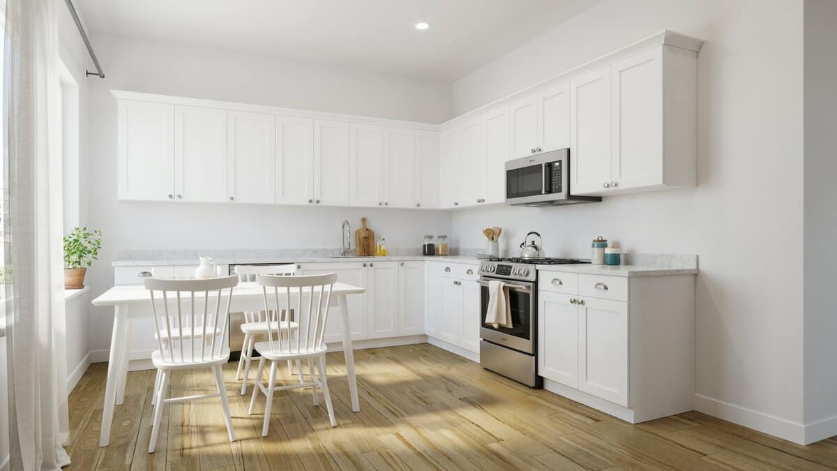White cabinets meeting at an inside corner with wood floors and white dining furniture