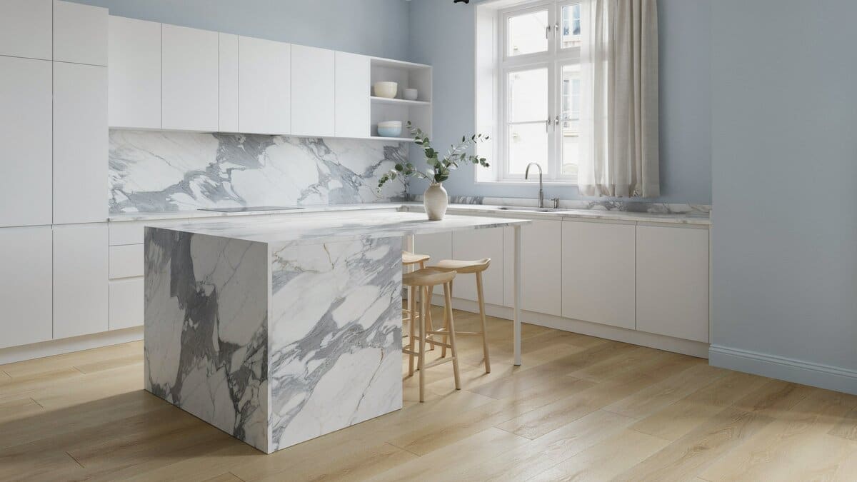 Calacatta marble counters and pastel blue walls paired with handleless white European cabinets