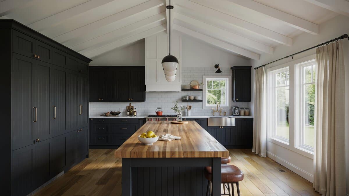 Black beadboard cabinet doors and a vaulted ceiling above a wood topped island