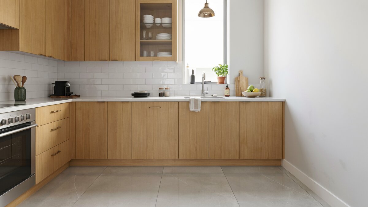 Light oak cabinets with chrome pulls, light gray walls and a white tile backsplash