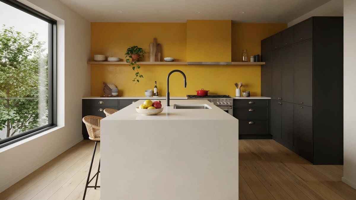 Bright yellow accent wall behind dark modern cabinets and a pale waterfall island