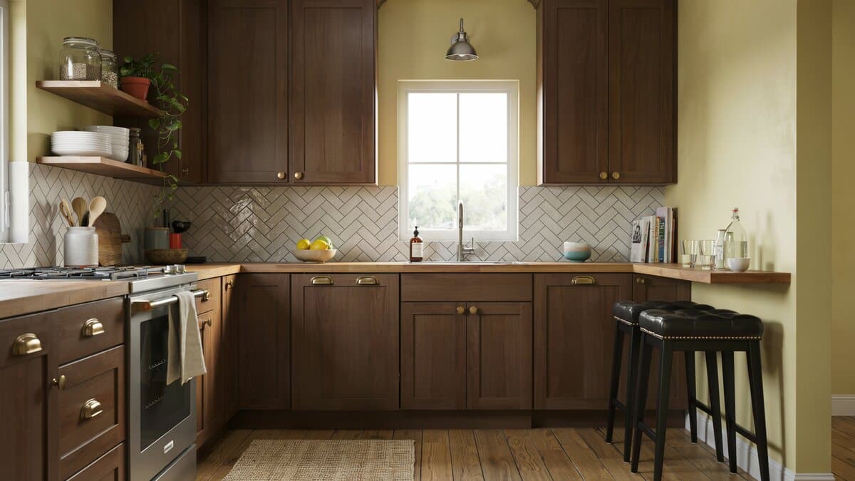 Pastel yellow walls softening dark cabinets above a herringbone tile backsplash