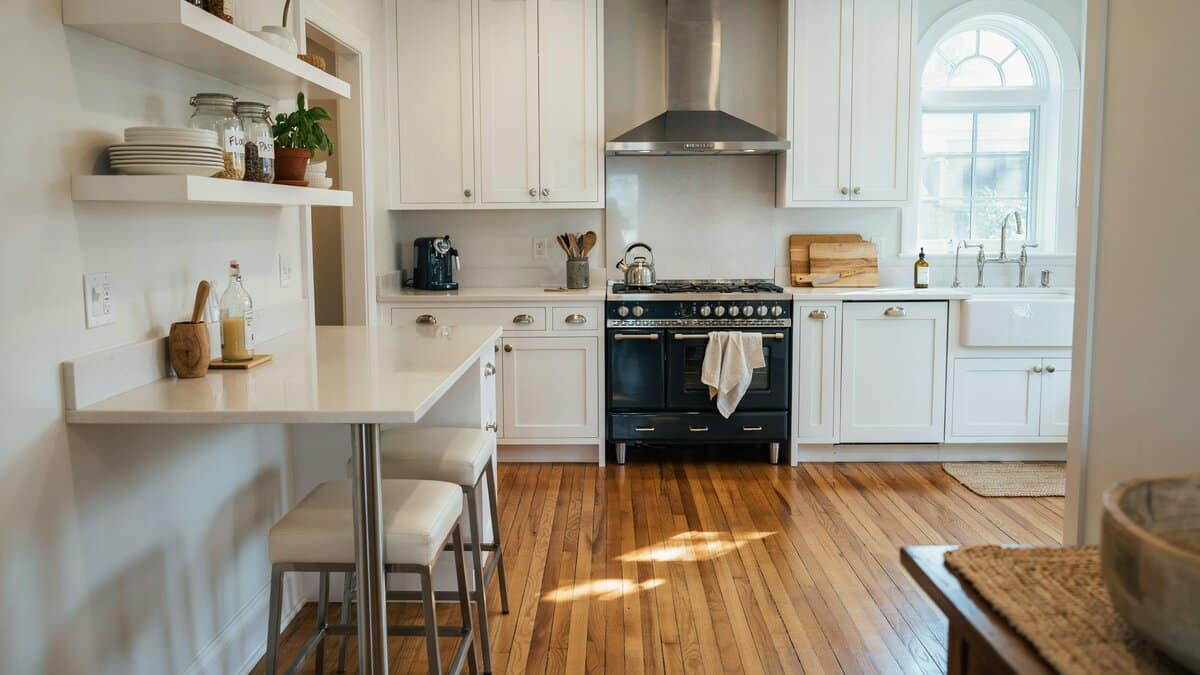 All white traditional cabinets with hardwood floors and a large industrial style range