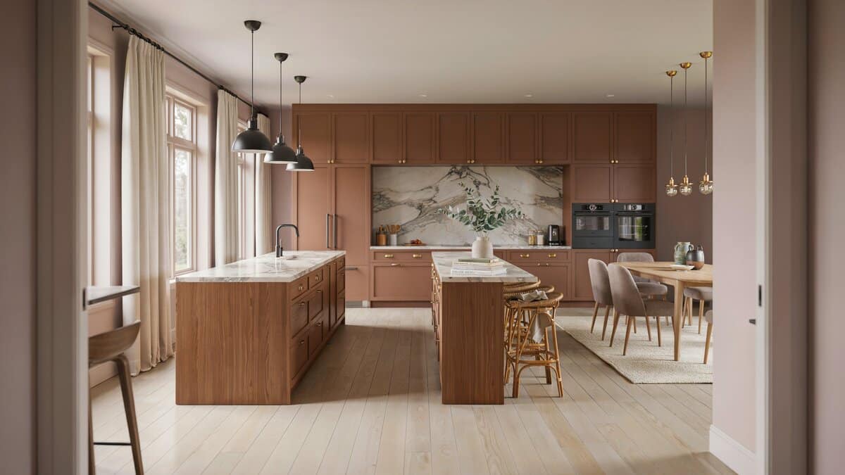 Soft mauve walls behind brown cabinets, twin islands and a round dining table