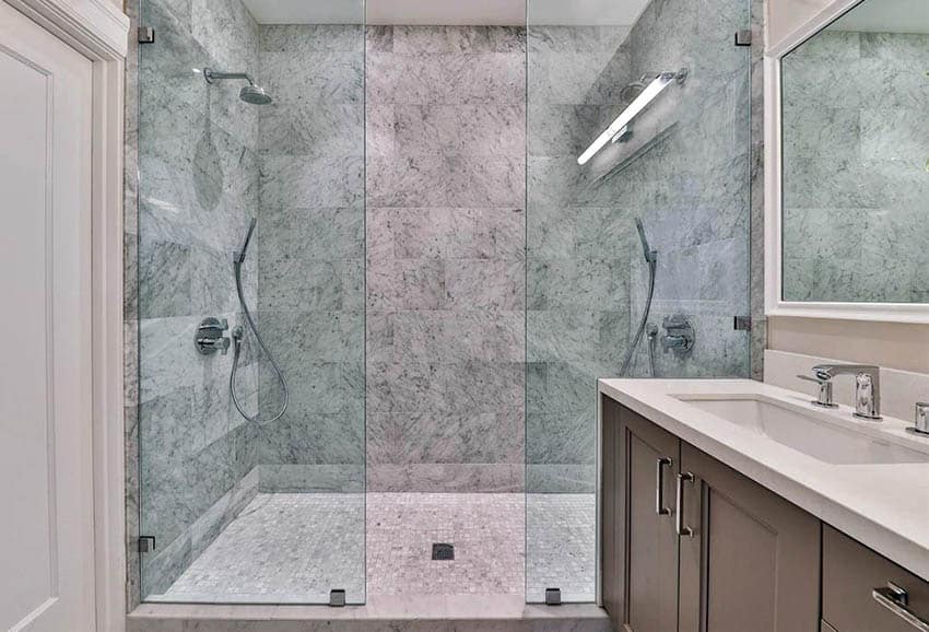 Walk in marble shower with mosaic tile floor