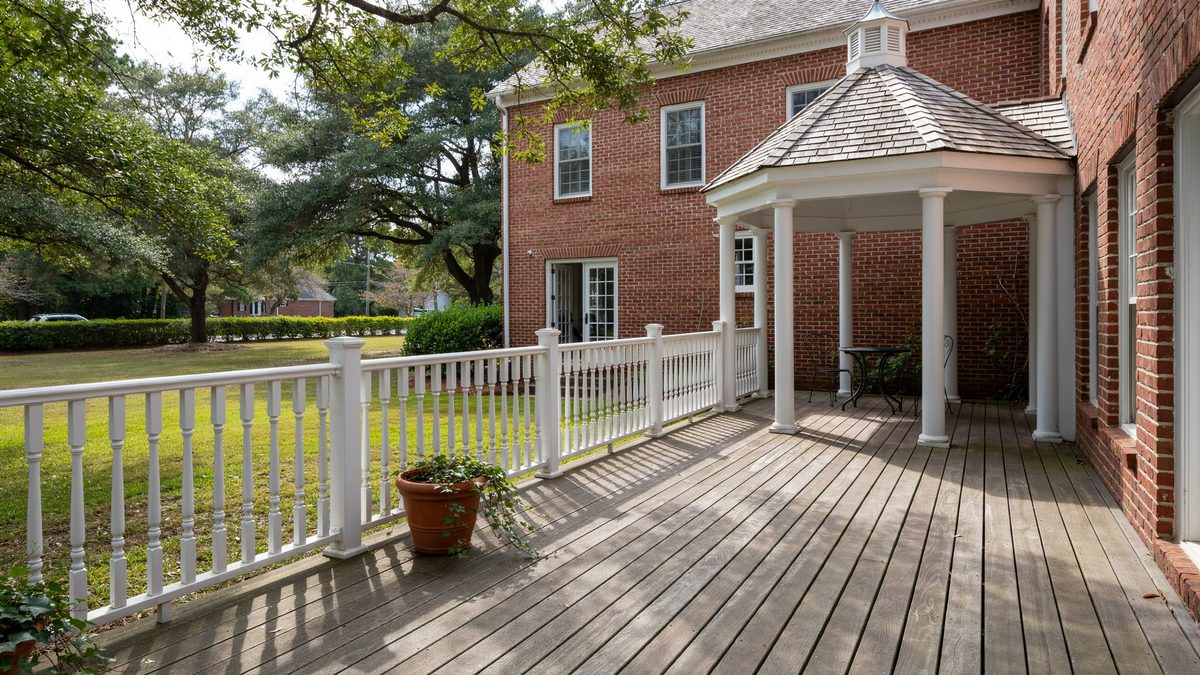 Colonial deck with white turned balusters and an attached white gazebo