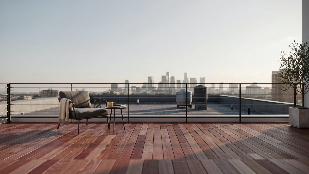 Rooftop redwood deck with black cable railing and city rooftops beyond
