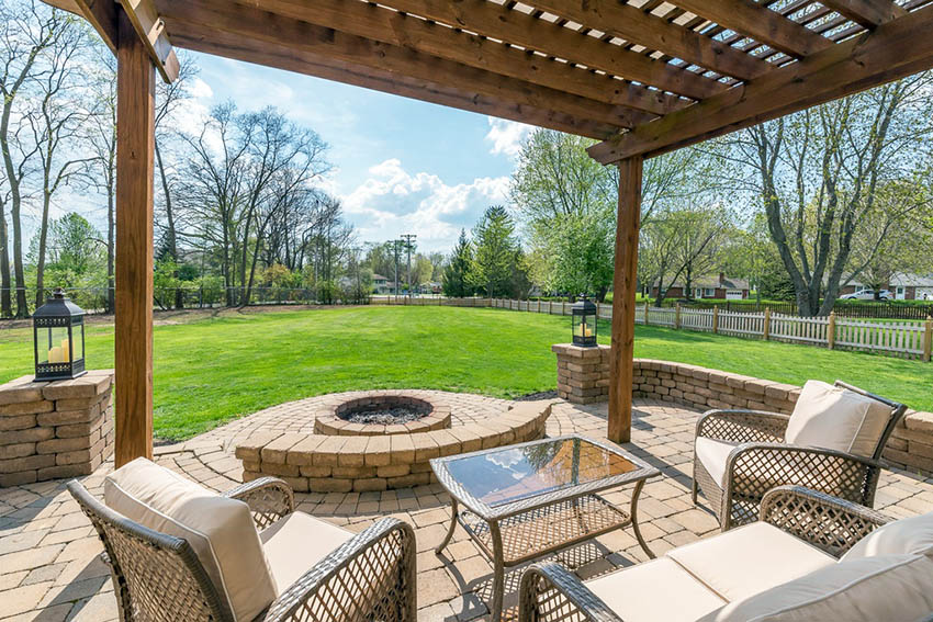 Backyard pergola with paver stone fire pit