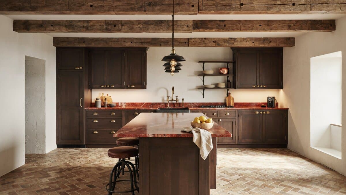 Rustic kitchen with dark custom cabinetry, red onyx counters and herringbone brick floor