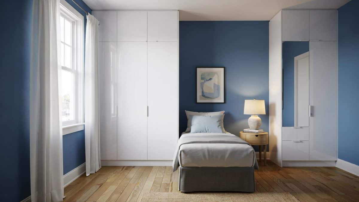 Bright blue guest room with white gloss closets and a single twin bed