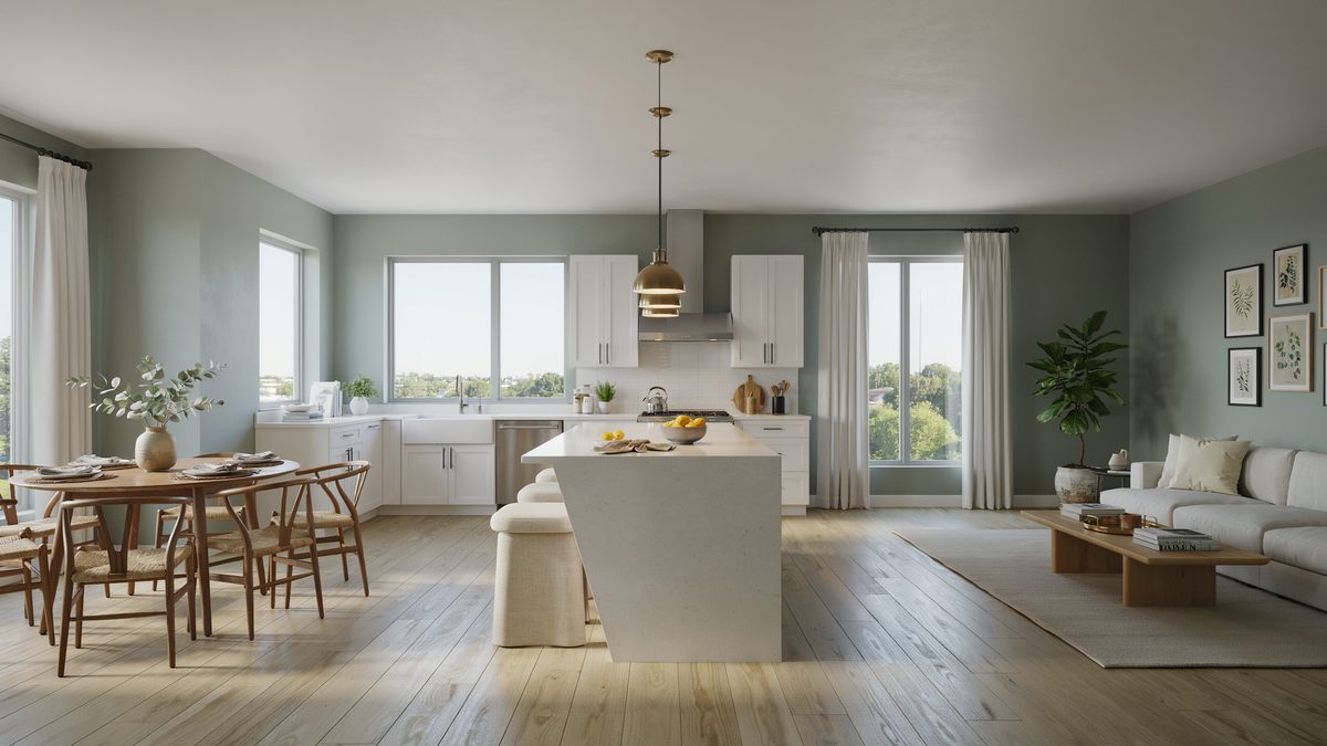 Muted green walls hold a white island between a dining table and living seating