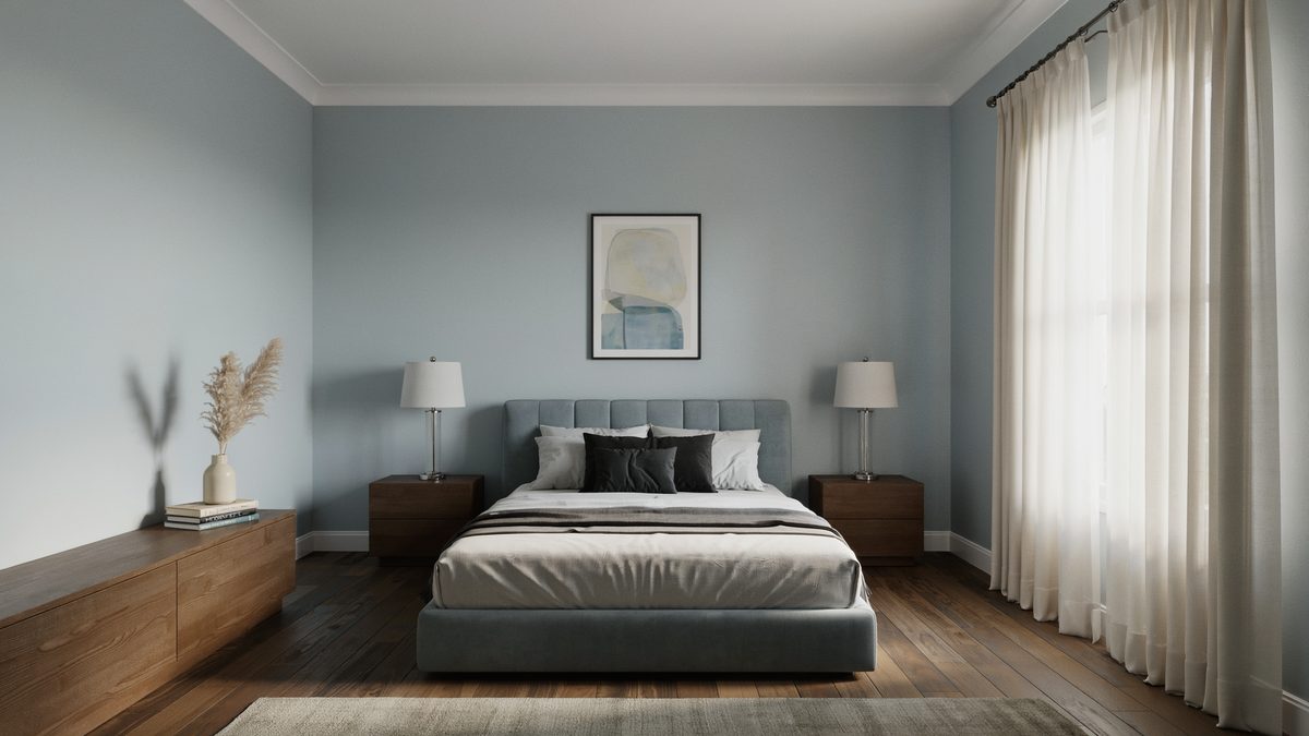 Powder blue gray walls with a gray upholstered bed and dark wood floor