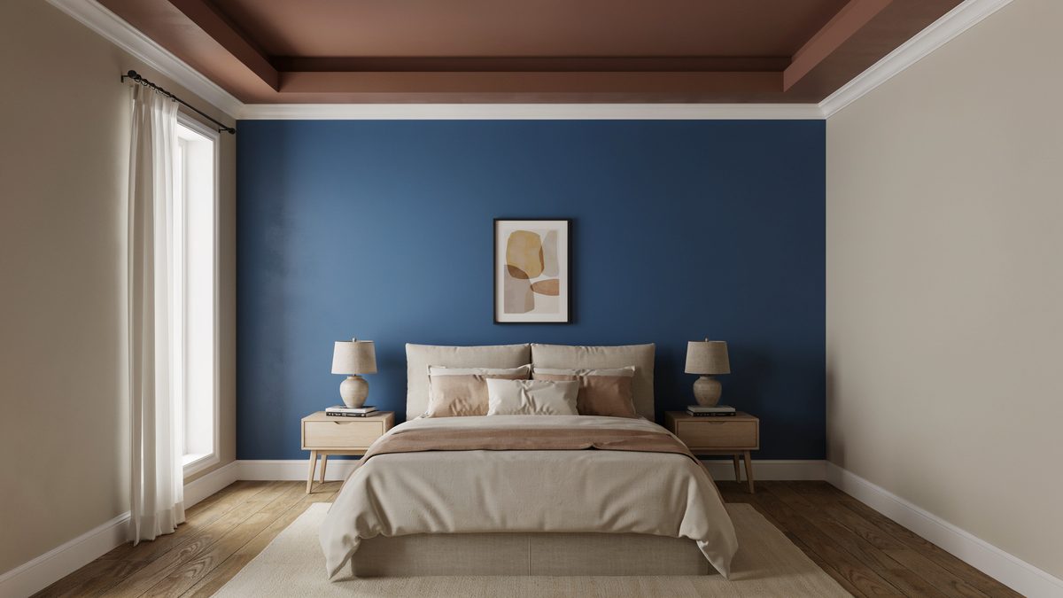 Blue accent wall behind the bed with a brown tray ceiling and beige walls