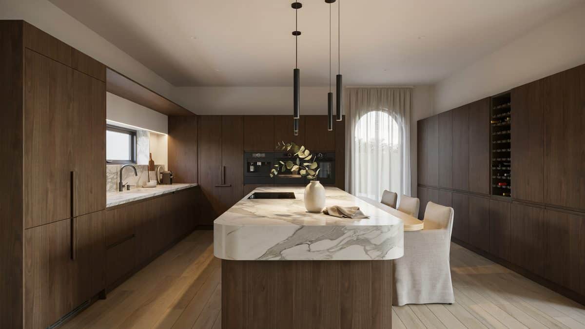 Walnut cabinets and a thick white marble waterfall island under black pendants