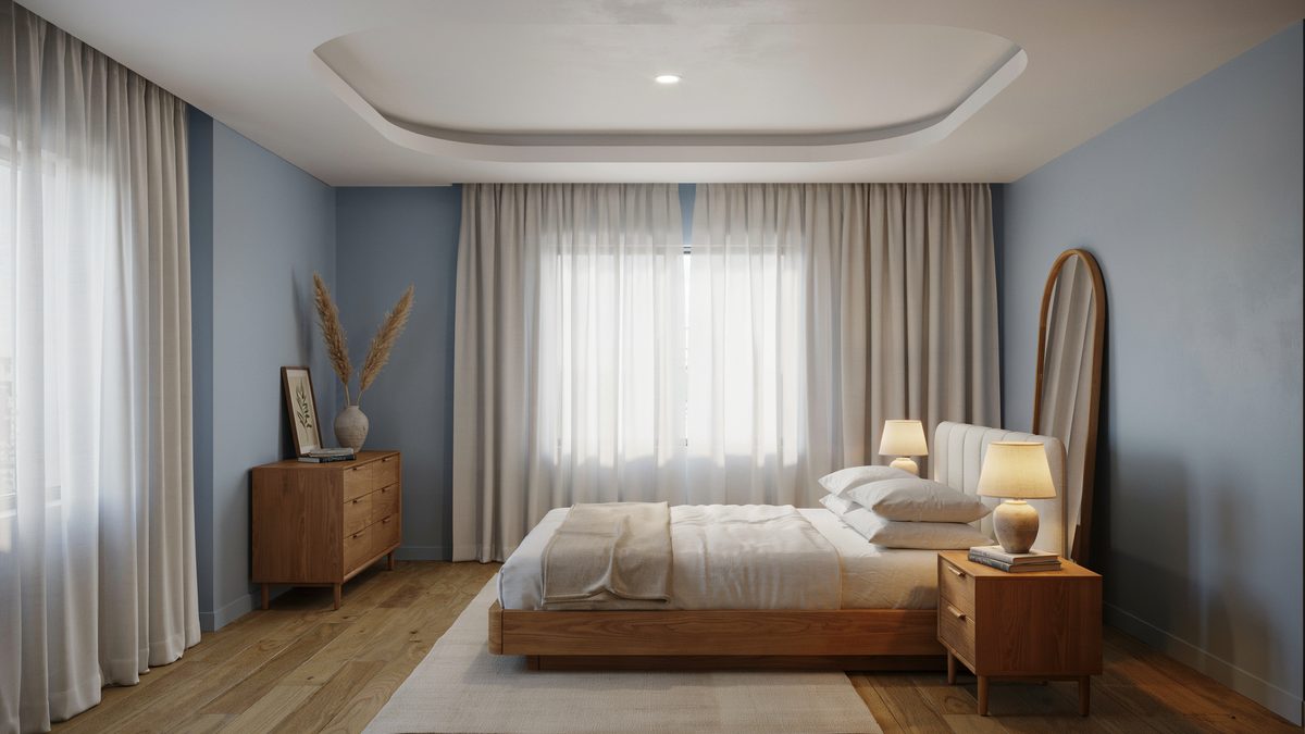 Light blue walls with an oval recessed ceiling, sheer curtains and wood dresser
