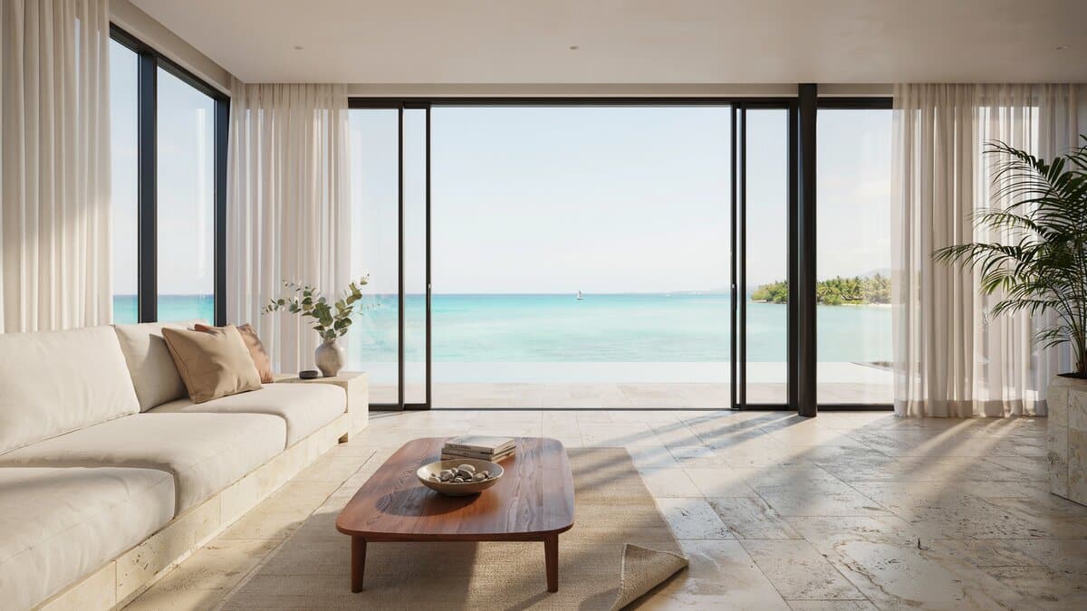 Gorgeous ocean view living room with wraparound windows and white furniture