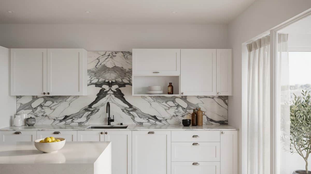 Book matched dark veined marble backsplash between white shaker corner cabinets