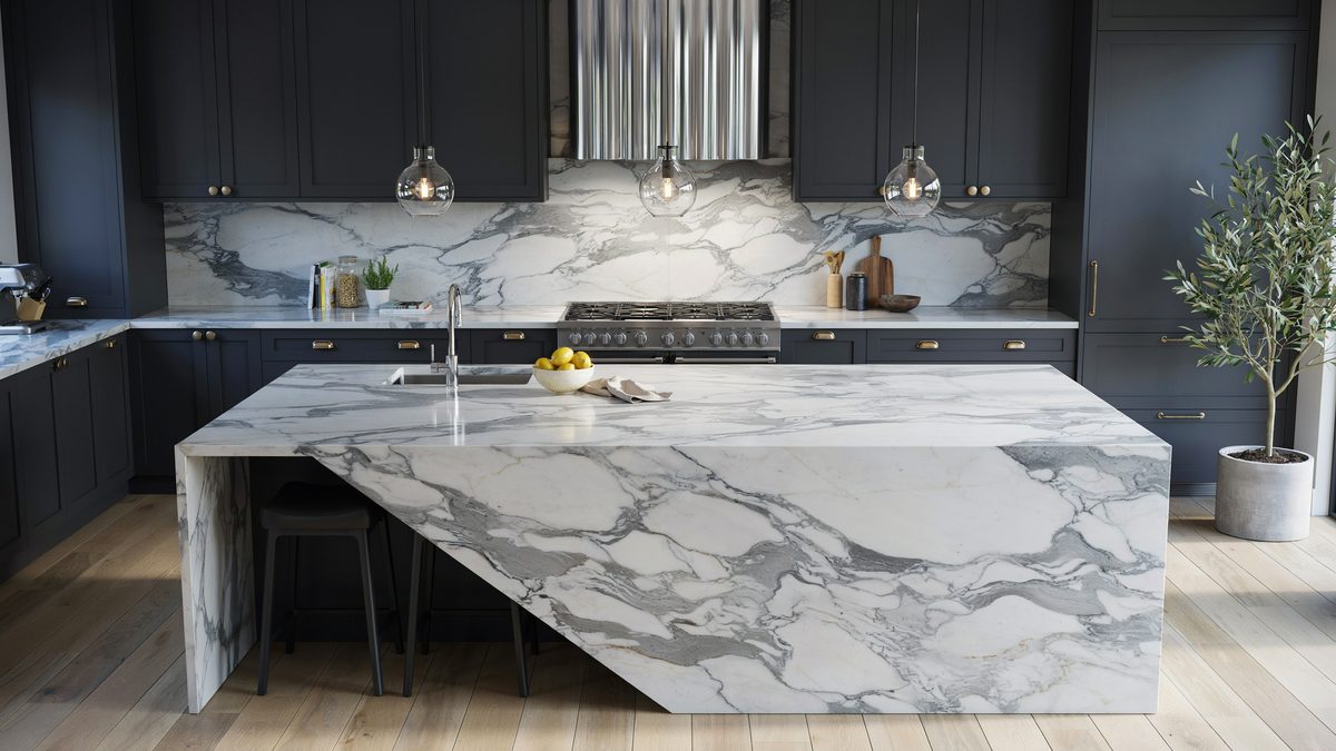 Charcoal cabinets paired with a boldly veined marble backsplash and mitered island