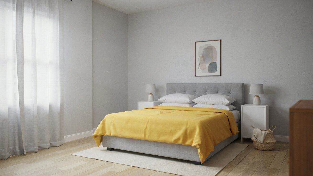 Bright yellow comforter covers a gray upholstered bed in a pale gray room