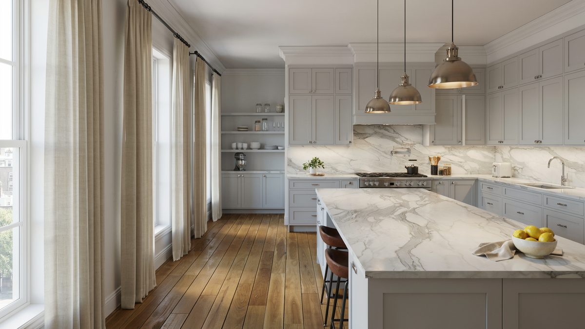 Light gray cabinets with veined marble counters under three nickel dome pendants