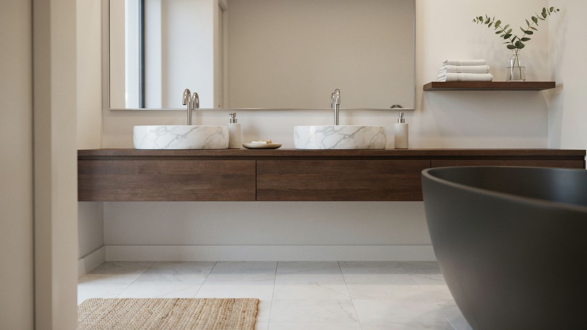 Walnut floating vanity holding two marble vessel sinks near a black soaking tub