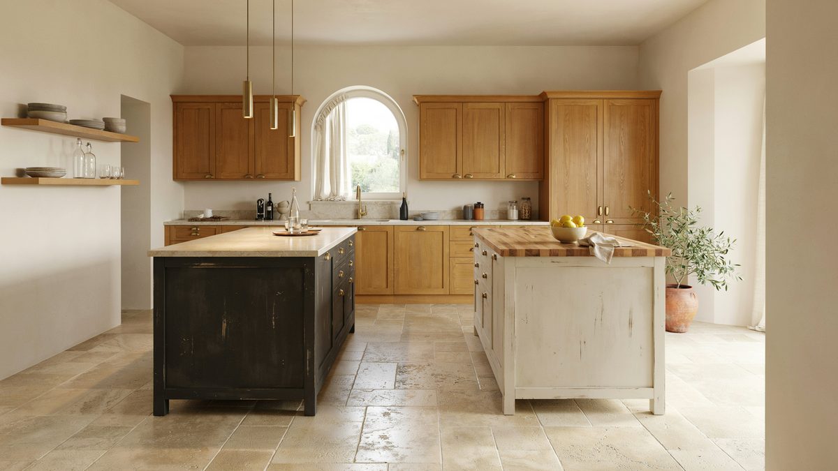 Black island and pale wood island resting on antique travertine floors