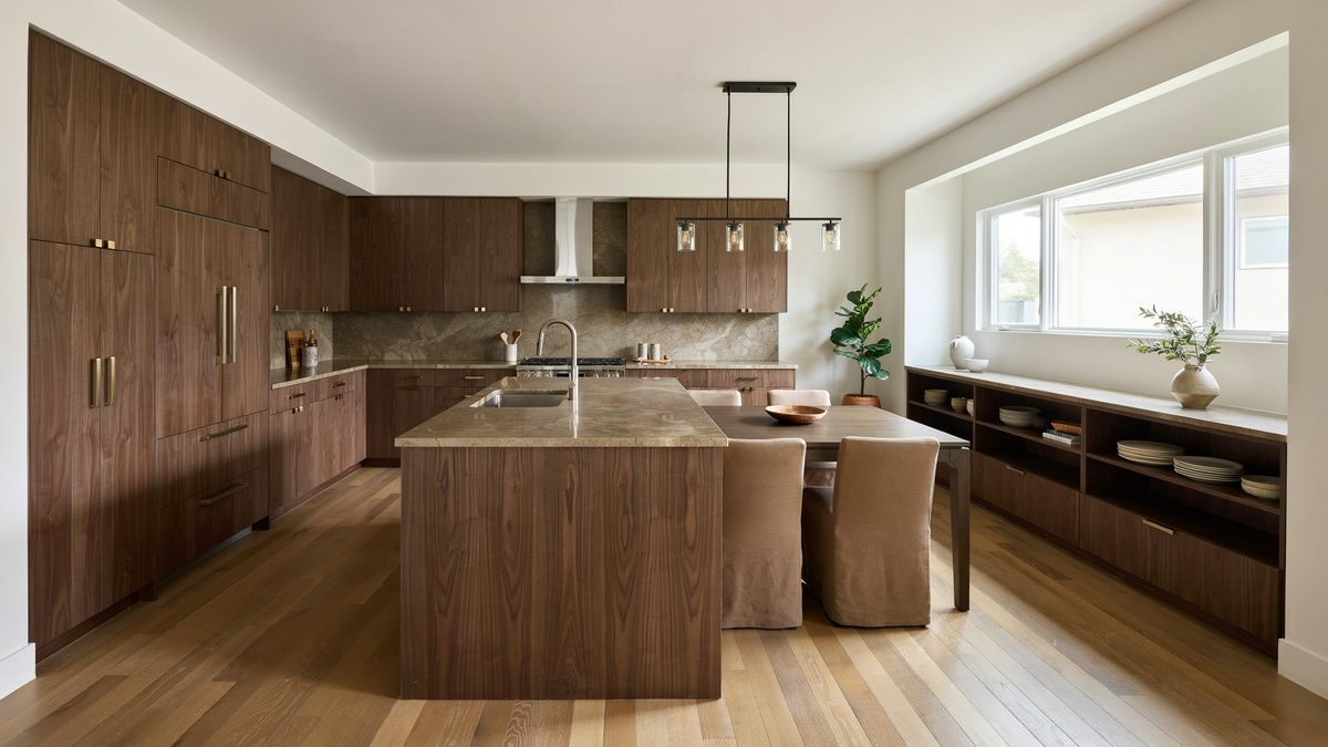 Walnut veneer runs wall to wall with a stone island and a low window buffet