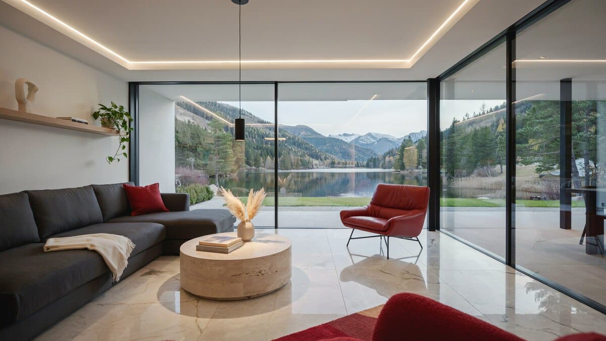Modern lake view living room with red and gray furniture