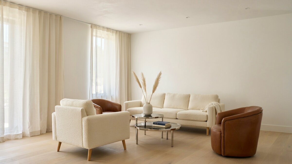 Modern living room with cream sofas and brown barrel chairs