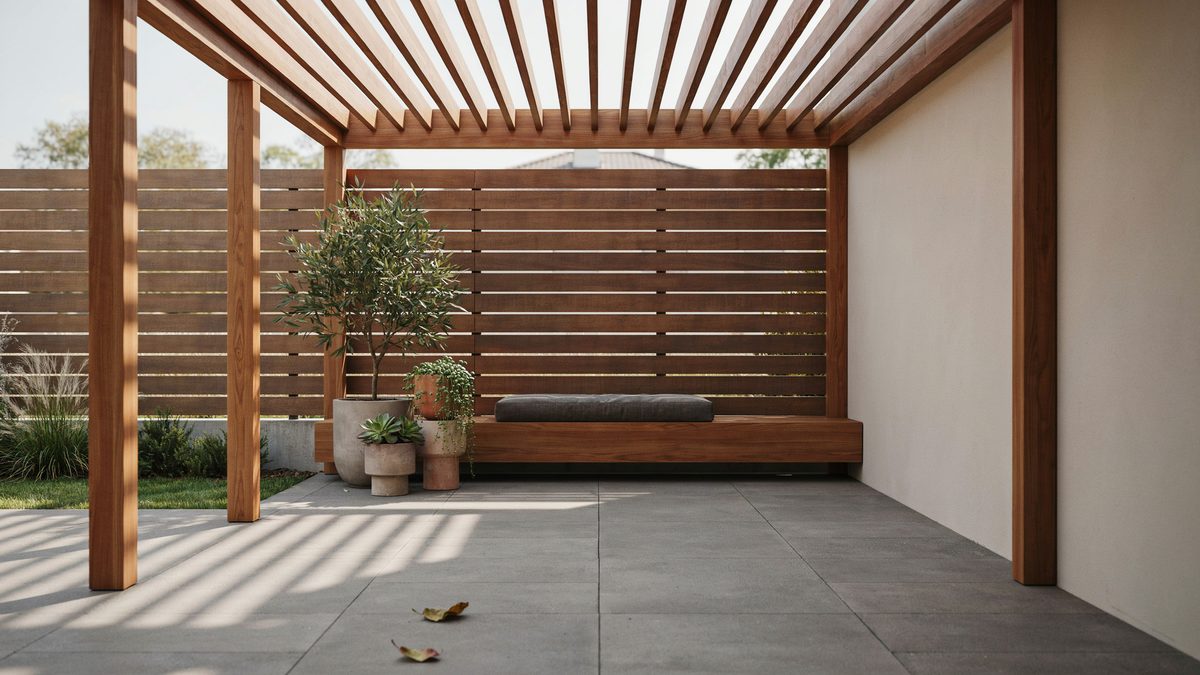 Warm wood pergola against a horizontal slat fence with built in bench seat