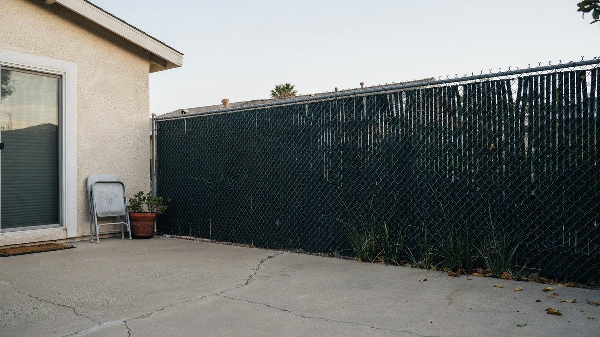 Dark green privacy slats woven through a tall chain link fence