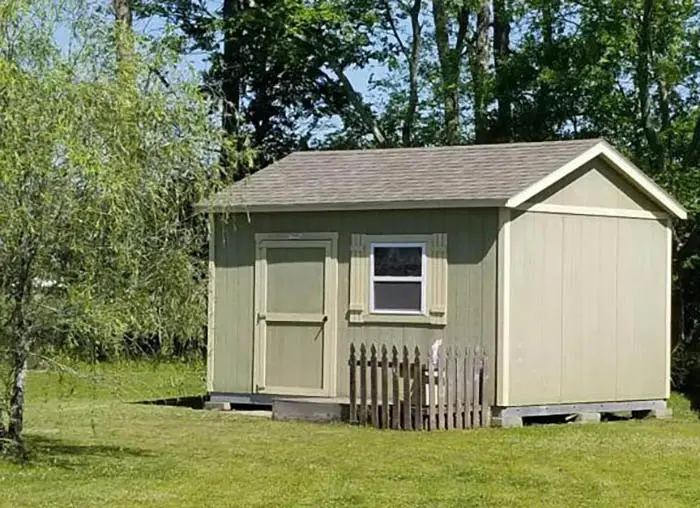 Light green shed with door and windows with storm shutters