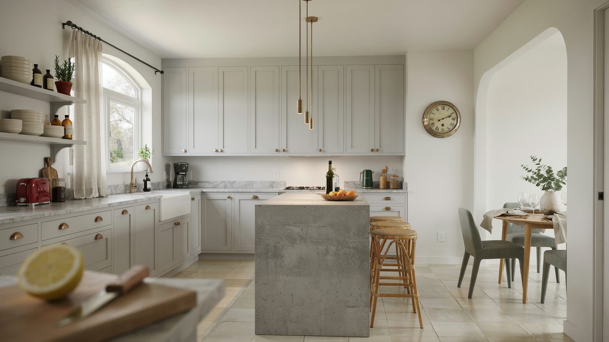 A concrete topped island faces an arched doorway and a compact dining table