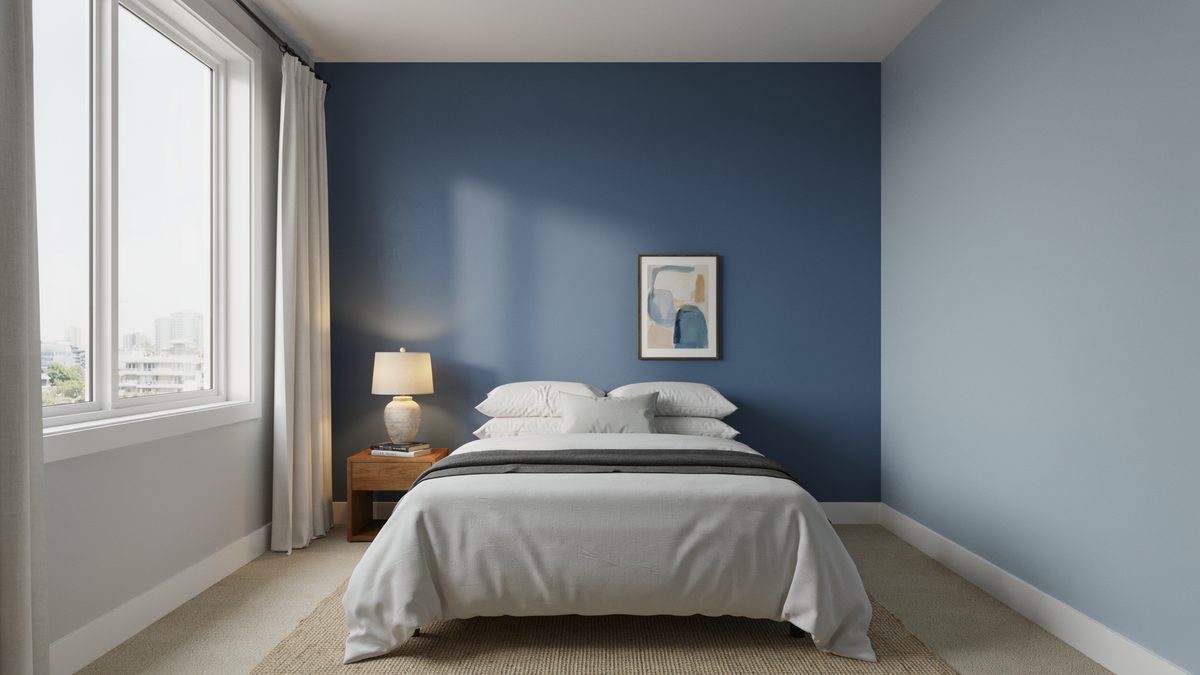 Two tone blue walls with a tall window, white molding and beige carpet
