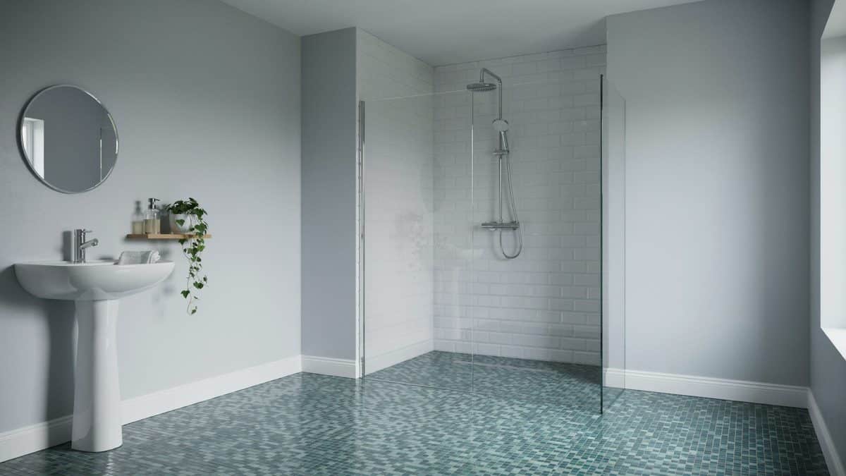 Teal glass mosaic floor in a small bathroom with pedestal sink and open shower