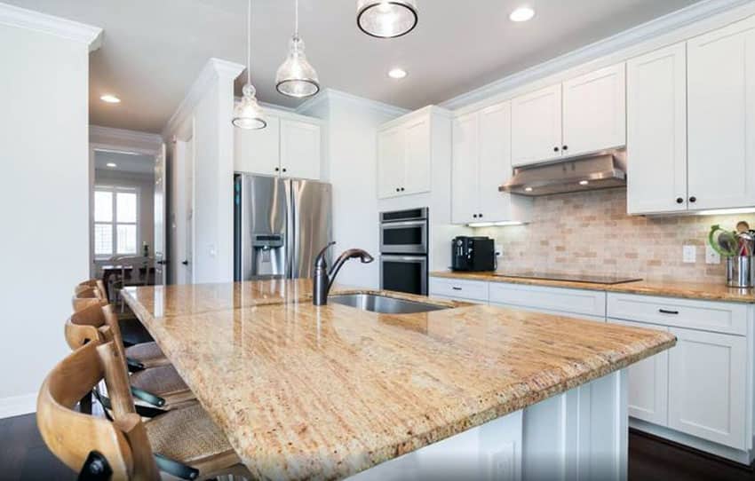 Bright white cabinetry, brown backsplash and pendant lights