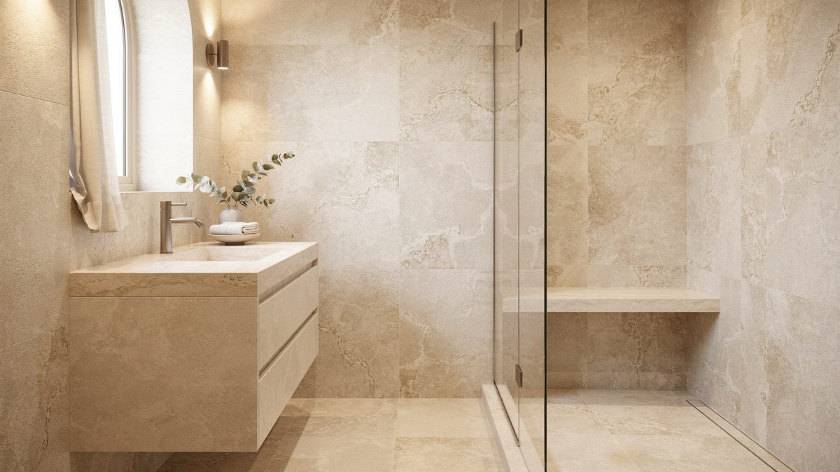 Bathroom clad in beige travertine tile with floating stone vanity and glass shower