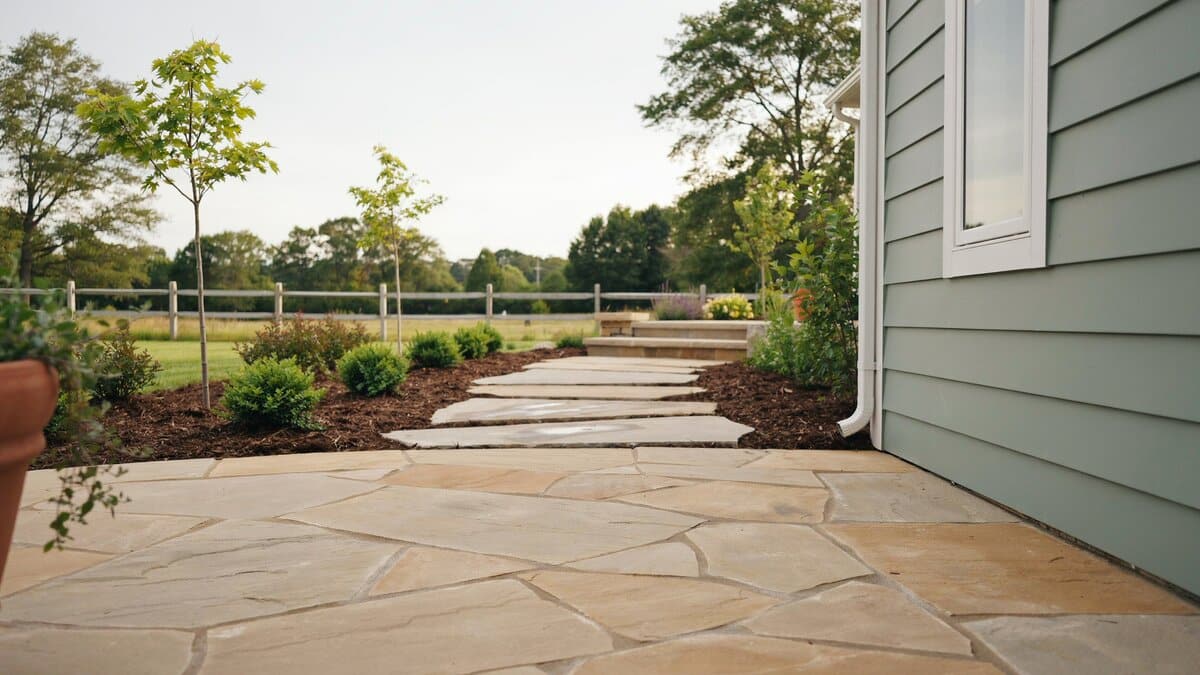 Coarse tan paving with dark bark mulch borders and wide flat stepping stones