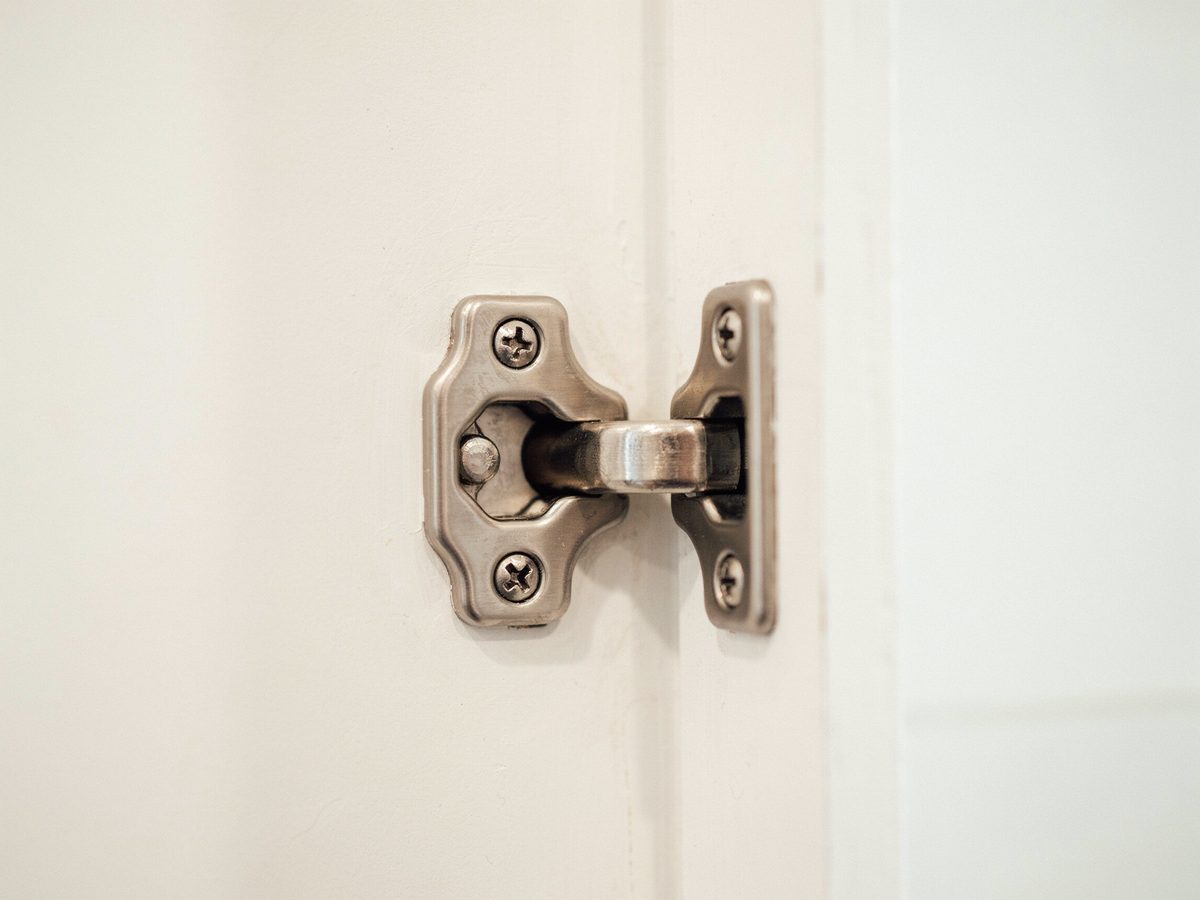 Full overlay concealed hinge open against a glossy white cabinet door