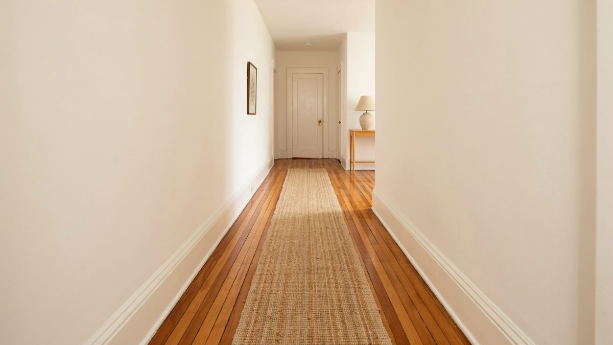 Long hallway with warm orange toned Douglas fir boards and a closed door