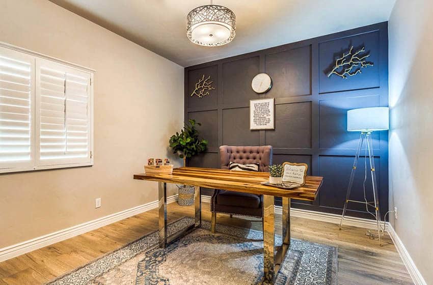 Home office with paneled wall and floor lamp