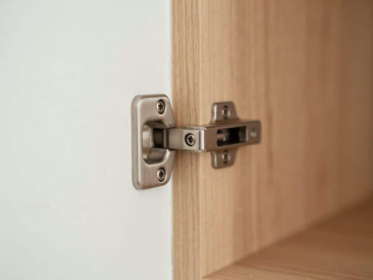 Inset concealed hinge joining an oak door flush with the frame