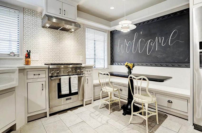 White cafe style chairs, black table with blackboard wall